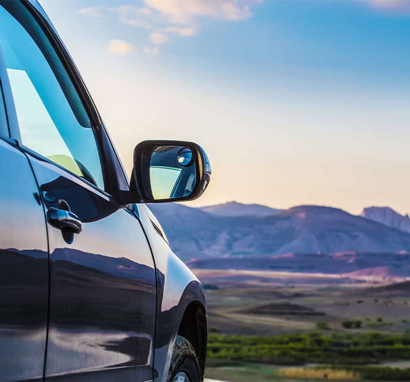 Vehicle parked near a mountain landscape.